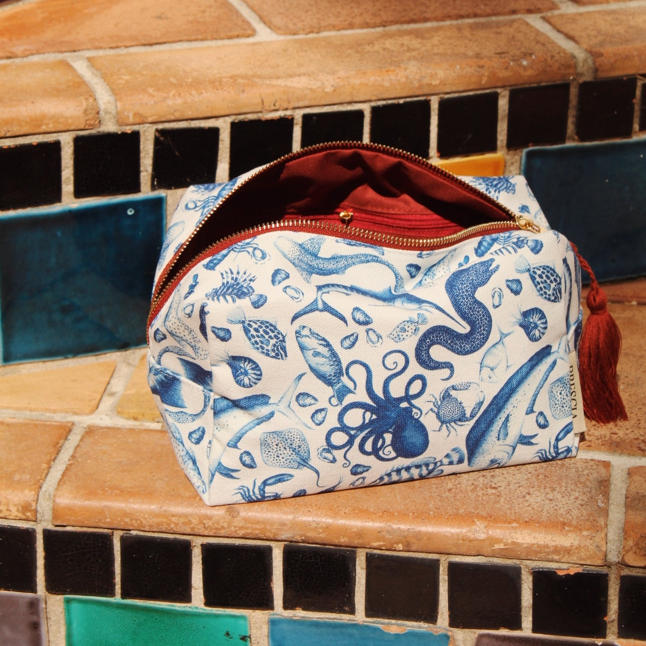 Brescia x Mission Blue Aquatic Affair canvas travel bag featuring hand-painted ocean species including chambered nautilus (Nautilus pompilius), giant Pacific octopus (Enteroctopus dofleini), queen triggerfish (Balistes vetula), Nassau grouper (Epinephelus striatus), blue marlin (Makaira nigricans), and ocean sunfish (Mola mola), supporting Mission Blue ocean conservation. Additional product view.